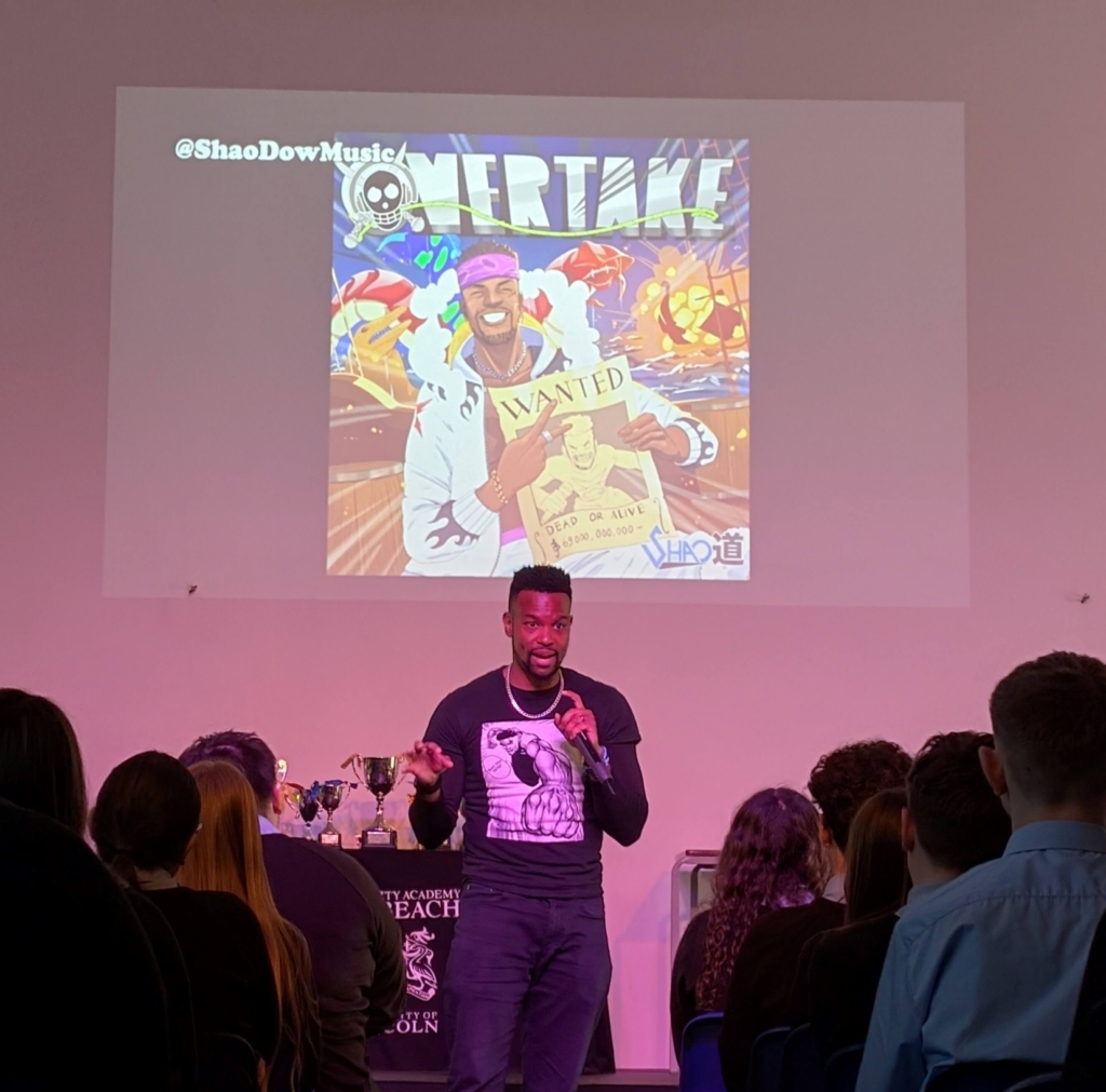 Artist performing in front of a large group of people - singing or rapping.