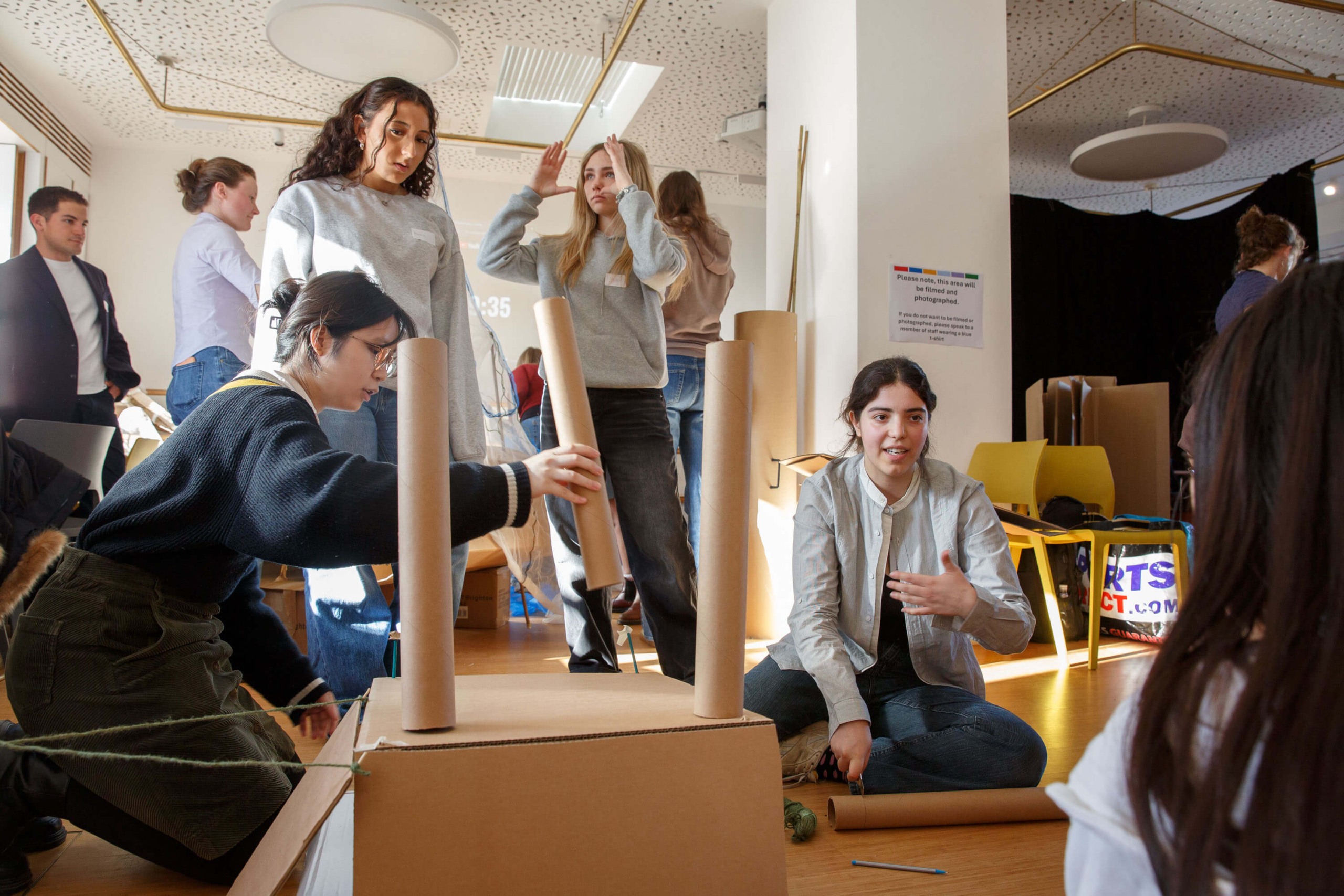 Work activity day learning about careers in architecture - secondary age students with cardboard boxes and tubes creating a physical structure.