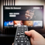 Person with a remote control switching channels on tv.