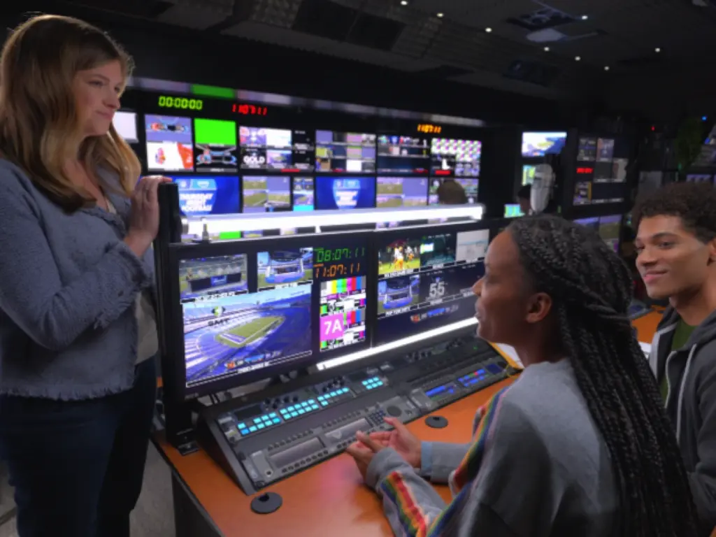 Amazon Prime Video working on technology, woman in front of desk of screens and computers handling video for film.
