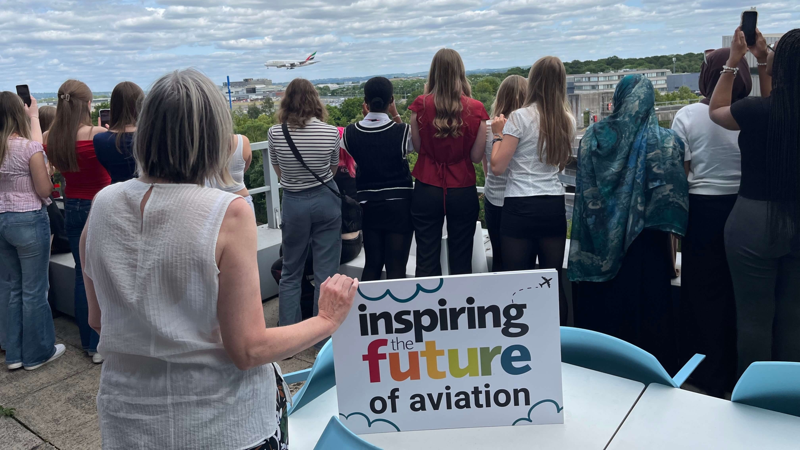 secondary children at Gatwick watching A380 plane landing on the runway
