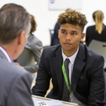 male secondary student talking to a volunteer one-to-one