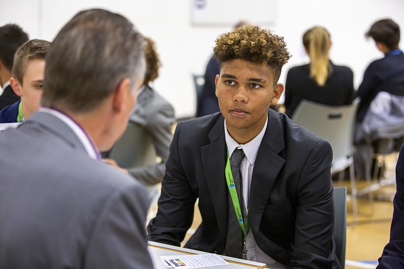 male secondary student talking to a volunteer one-to-one