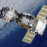 Satellite with solar panels orbiting above Earth, showcasing advanced space manufacturing and technology.